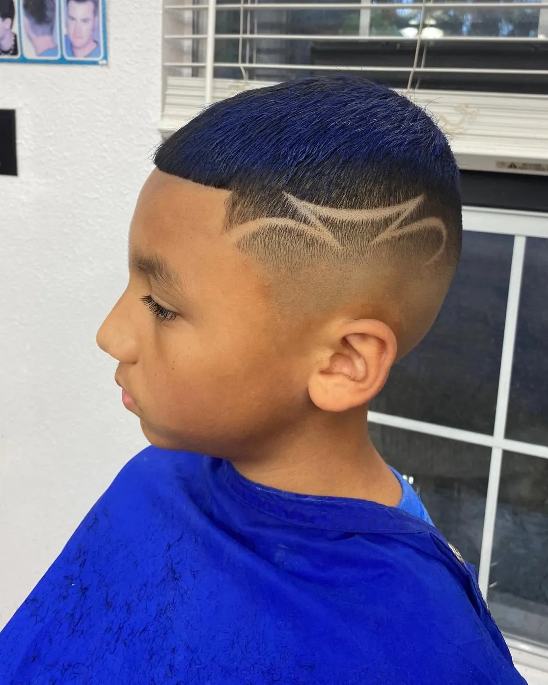 A boy's fresh fade with a line design, in the salon chair