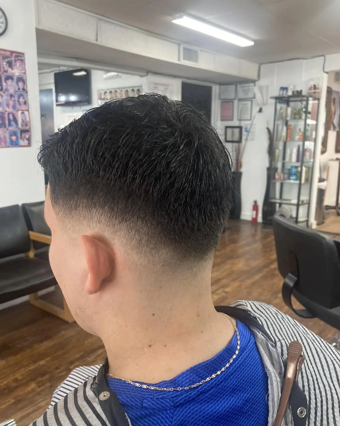 Men's fade with a freehand line design shaved above the ear